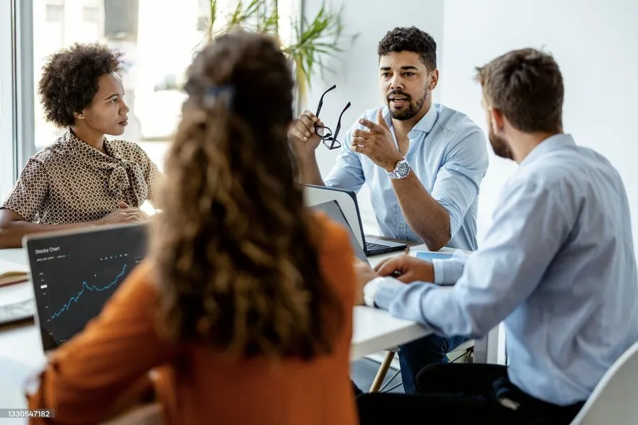 Colleagues talking around a table in an office.